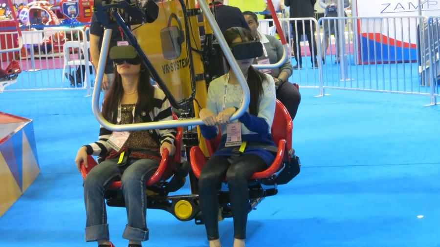 Attendees at the IAAPA expo in Orlando try a new virtual reality swing ride. 