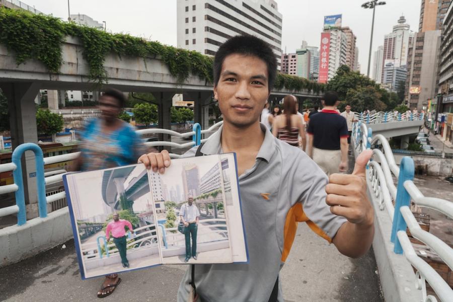 Wu Yong Fu holding portrait album on the bridge, July 30, 2009