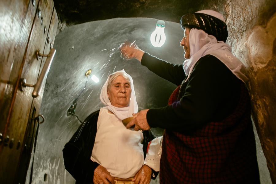 Yazidi religious leader Asmar Asmail pours water on the head of Hure Kaso Murad, a key step in the reintegration ritual after she was forcibly converted to Islam.