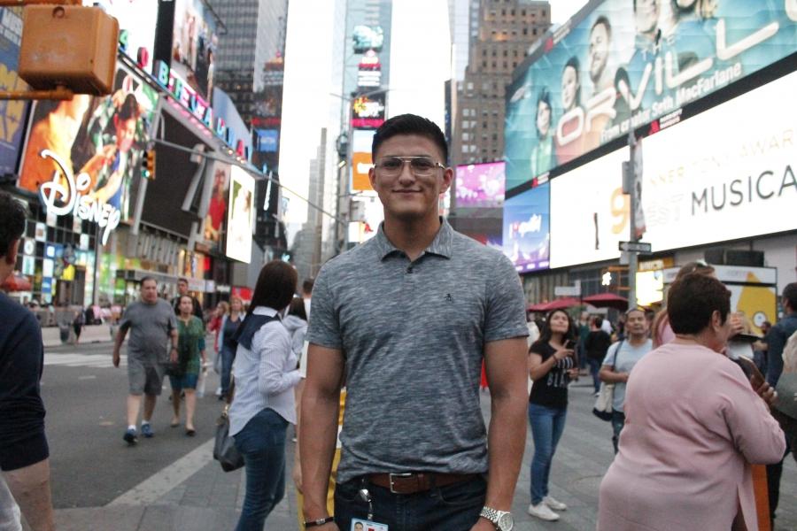 Man standing in Times Square, smiling