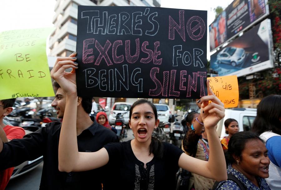 A woman holds a sign as she takes part in the #IWillGoOut rally, to show solidarity with the Women's March in Washington, along a street in Ahmedabad