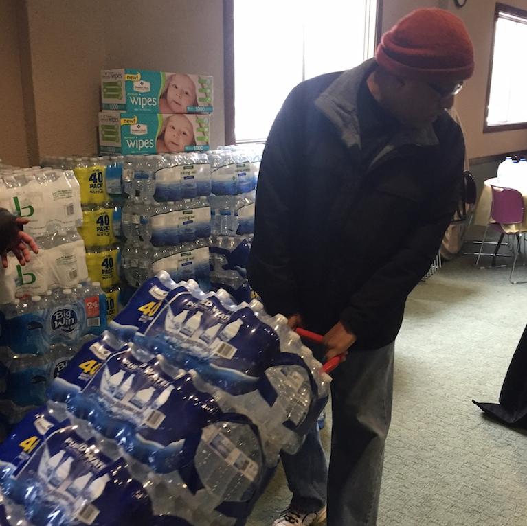 A volunteer hauls water off a truck in Flint, Michigan