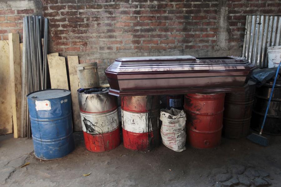 A coffin lies on barrels at El Nuevo Renacer factory in Jucuapa.