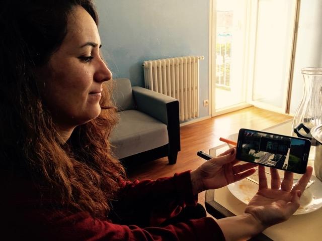 Inside the Nohs' apartment in Saint-Nazaire, Suham Noh shows a photo of the family home they had to flee in the Sinjar region of Iraq.