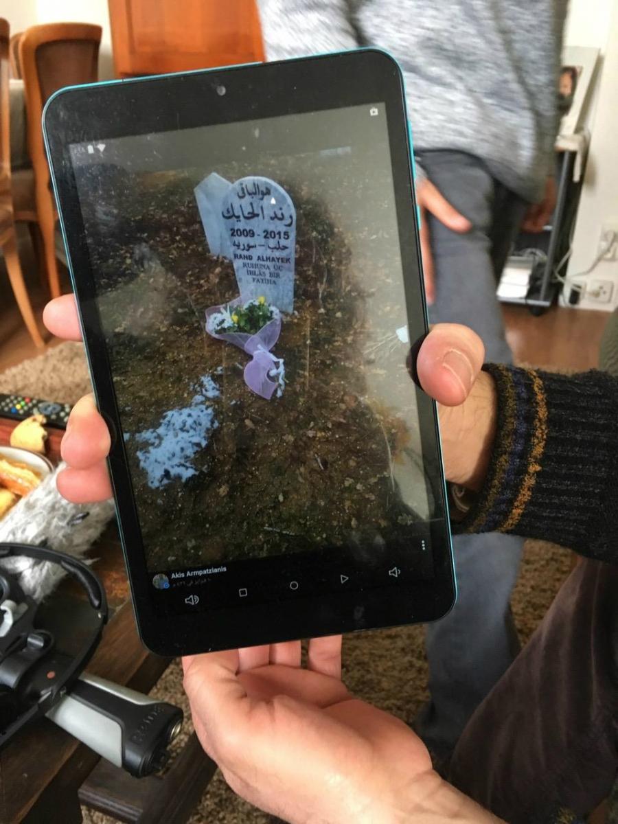 Mahmoud al-Hayek shows a photo of his daughter Rand's gravestone in Greece. Rand, 6, was killed by a train after the family crossed from Turkey into Greece as refugees.