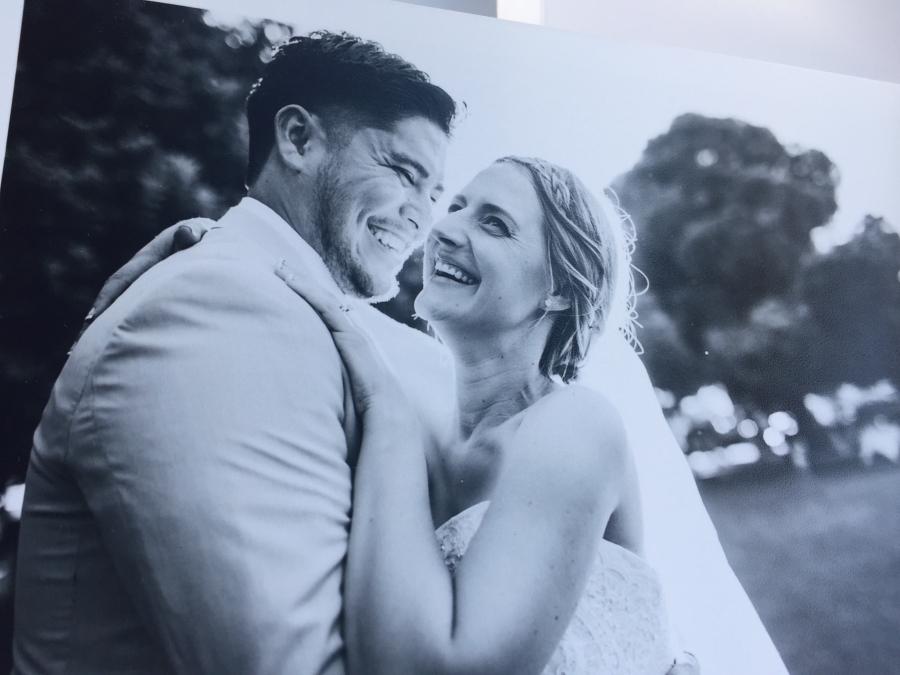 photo of a black and white photo of bride in white gown and groom, smiling