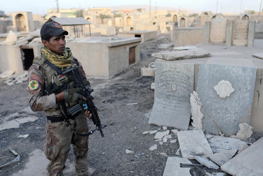 An Iraqi special forces soldier stands in a Christian cemetery damaged by ISIS fighters in Bartella, east of Mosul, Iraq, Oct. 21, 2016.
