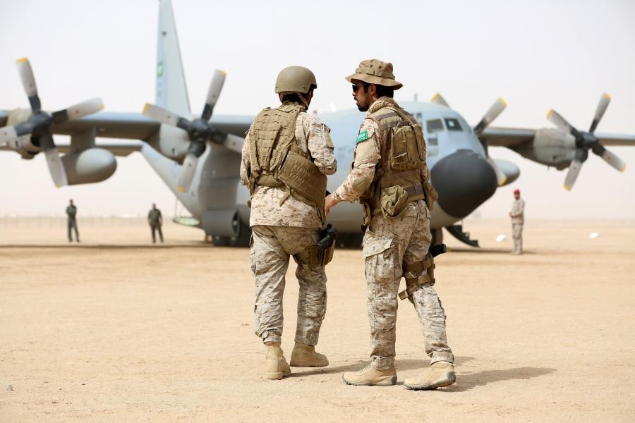 Saudi soldiers walk past a Saudi air force cargo plane delivering aid at an airfield in the northern province of Marib, Yemen, Jan. 22, 2018.