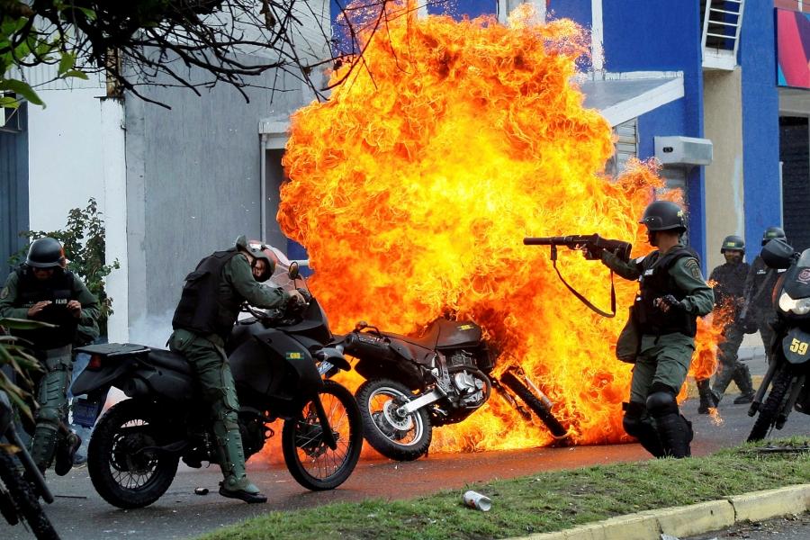 Riot security forces clash with demonstrators as a motorcycle is set on fire during a protest against Venezuelan President Nicolas Maduro's government in San Cristobal, Venezuela, May 29, 2017. 