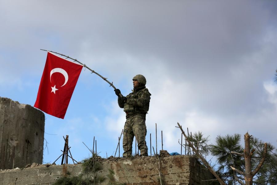 A Turkish soldier waves a flag on Mount Barsaya, northeast of Afrin, Syria, Jan. 28, 2018. Turkey and allied Syrian rebel groups have opened a new front in Syria’s multisided war with an assault on the territory against the US-backed Kurdish militia, the 