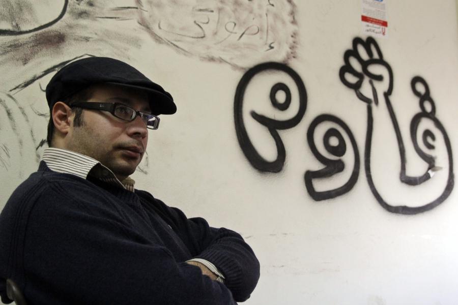 Ahmed Maher photographed in January 2013, in the headquarters of the April 6 Movement. The writing on the wall reads “resist.”