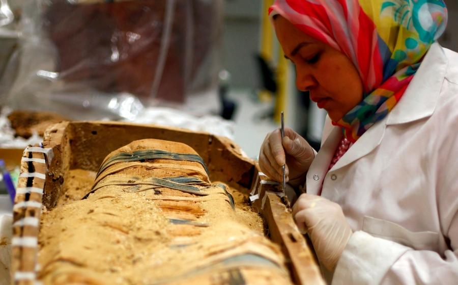An Egyptian archaeological technician renovates one of the mummies which belonged to The Golden King Tutankhamun