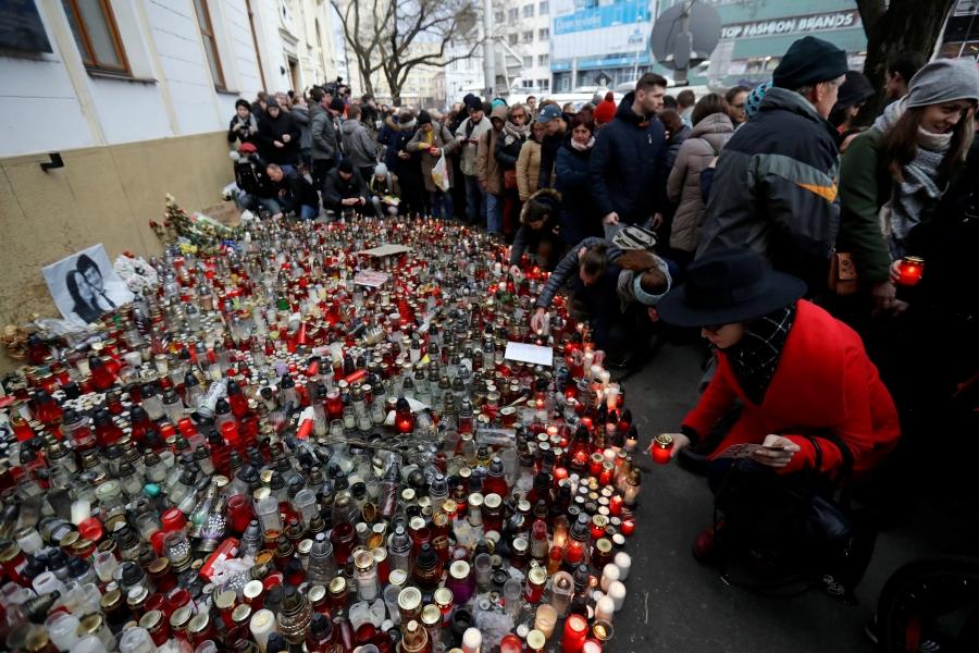 People light candles during a march in reaction to the murder of Slovak investigative reporter Jan Kuciak and his fiancee Martina Kusnirova,