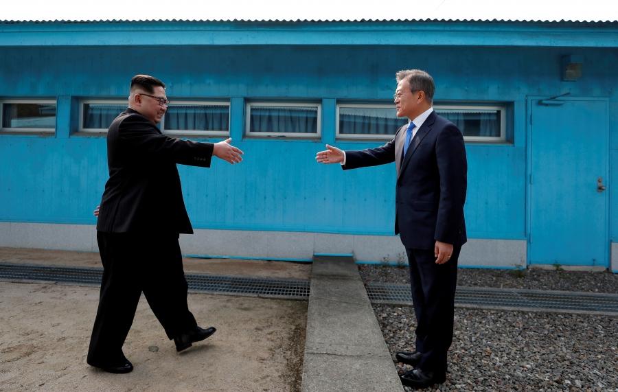 South Korean President Moon Jae-in and North Korean leader Kim Jong-un approach to shake hands during their-first ever meeting at the truce village of Panmunjom inside the demilitarized zone separating the two Koreas, April 27, 2018. 
