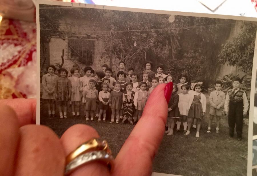 Lisette Shashoua points out classmates in a school photo from her childhood in Baghdad. She and her friends consider the photo album a treasure. When they fled Iraq, most Jewish families were forced to leave everything behind. 