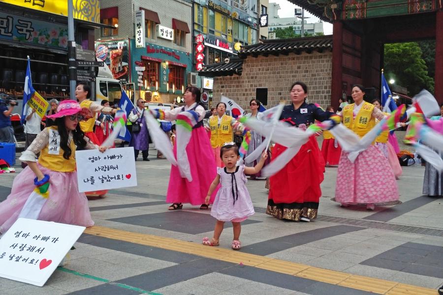 A young girl waves South Korea's national flag during an anti-LGBT, conservative Christian protest
