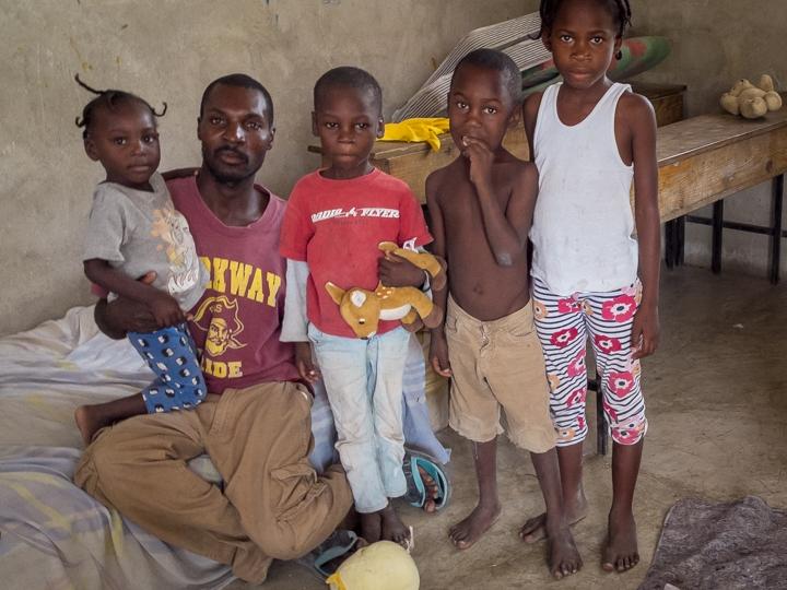 Sensoirre Subelensa sits with his children in one of four classrooms at a school in Fond Parisien, Haiti. Subelensa arrived in the Dominican Republic at age 7 and lived there for 28 years. He says he was grabbed by police in June and forced out of the cou