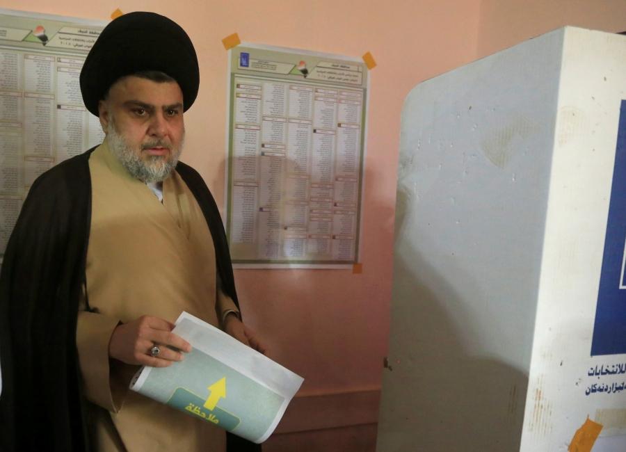 Iraqi Shi'ite cleric Moqtada al-Sadr attends to cast his vote at a polling station during the parliamentary election in Najaf, Iraq, on May 12, 2018.