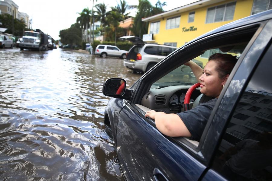 Woman in car on flooded street