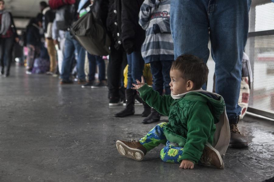 A young Central American boy sits while waiting in the line of asylum seekers who turned themselves in at the U.S. border on Sunday, May 7, 2017. 