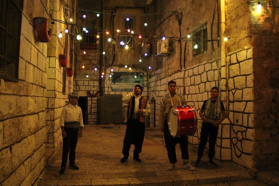 Young Palestinians in Jerusalem's Old City volunteer as public wakers, called musaharati, to sing and drum in city streets during Ramadan