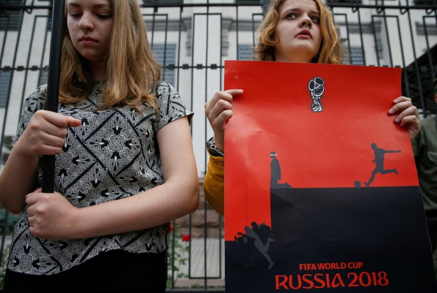 A demonstrator holds a poster during a rally demanding the liberation of Ukrainian film director Oleg Sentsov by Russia, in front of the Russian embassy in Kiev, Ukraine, June 13, 2018. 