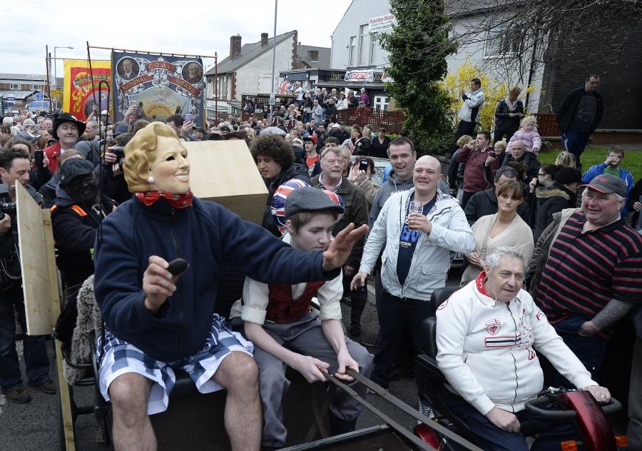 Parade with person in Margaret Thatcher mask 