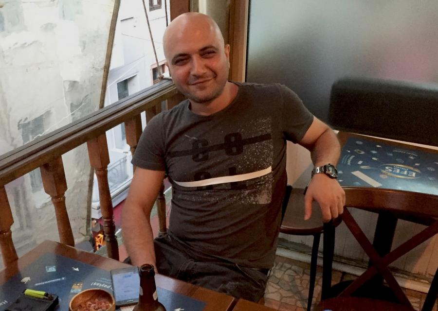 Bilal Dündarlioğlu, a 34-year-old information technology engineer in Turkey, sits at a cafe table.