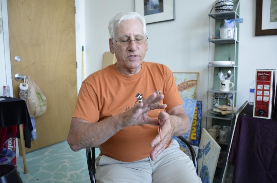Bruce Ward performs a magic trick with rubber bands. The former steel worker has reinvented himself with a number of jobs — including as a photographer, videographer, and magician — since being laid off from the mill in Bethlehem two decades ago. 