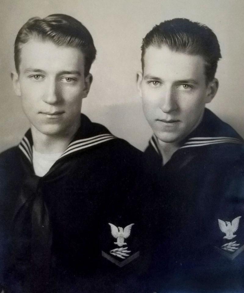 Two young men are pictured in military uniforms from the 1940s. They are twins. 