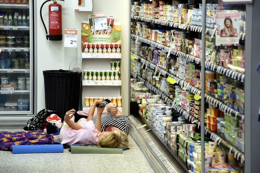 Customers are seen laying on a mattress at local grocery store to cool off. 