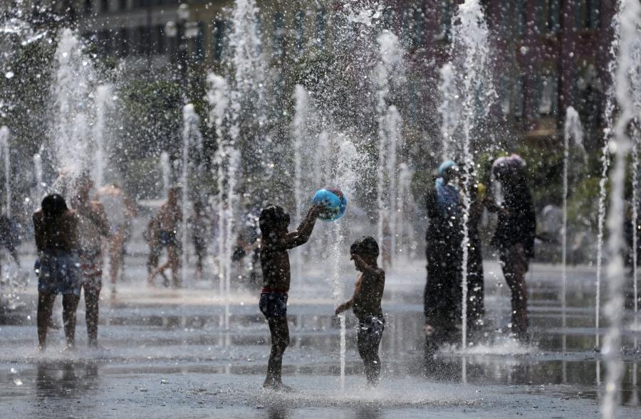 People cool off in water fountains in Nice, France. 