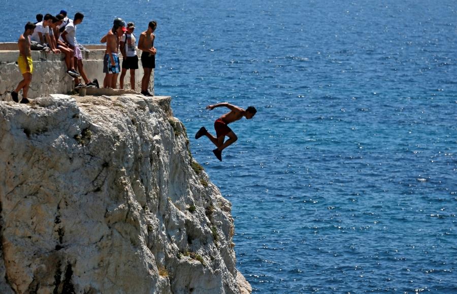 A teenager dives into the Mediterranean Sea in Marseille, France.