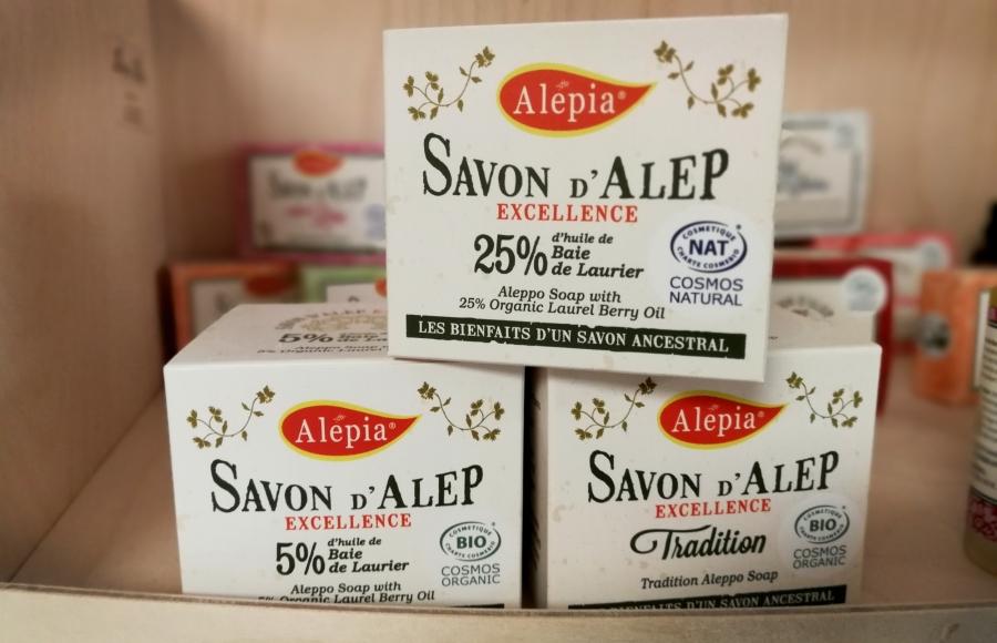 Packaged soap sits on a shelf. The packages are written in French with the name "Alepia."