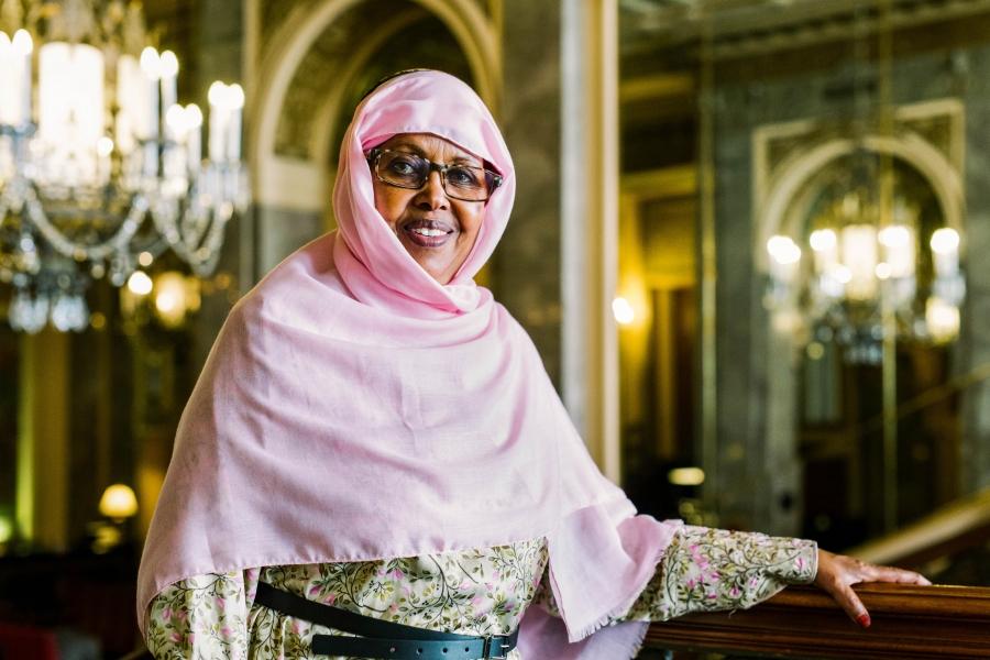 Shukri Haji Ismail is shown in a pink shawl with dark-rimmed glasses.