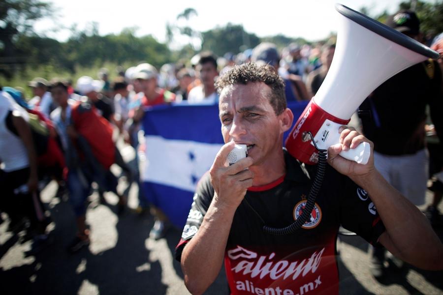 Central American migrants shout slogans and one man spoke into a megaphone.