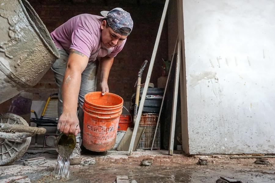 a man works with bricks and cement to build a house in argentina