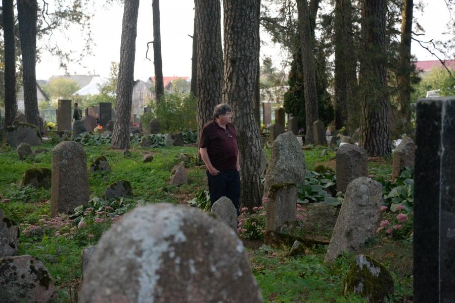 Man standing in lush cemetery