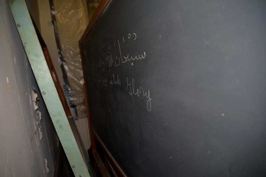 Old chalkboard with writing in Arabic and English