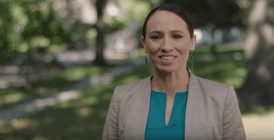 Sharice Davids stands under trees and smiles 