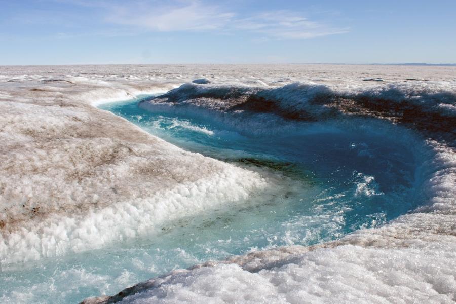 A river of fresh icemelt carves its way through the Greenland ice sheet.