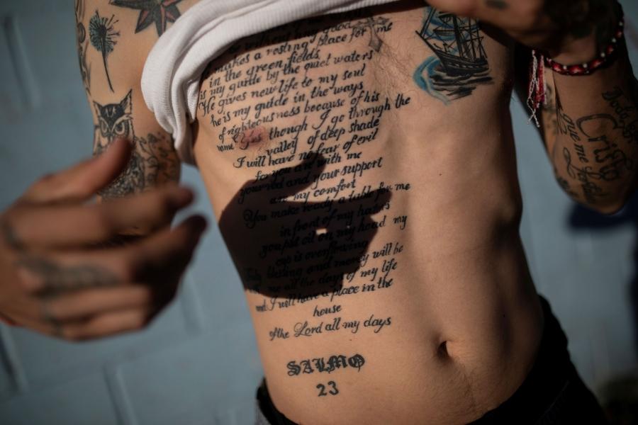 Juan Francisco is shown lifting his white shirt up to reveal a large tattoo of the 23rd Psalm of the Book of Psalms written out.