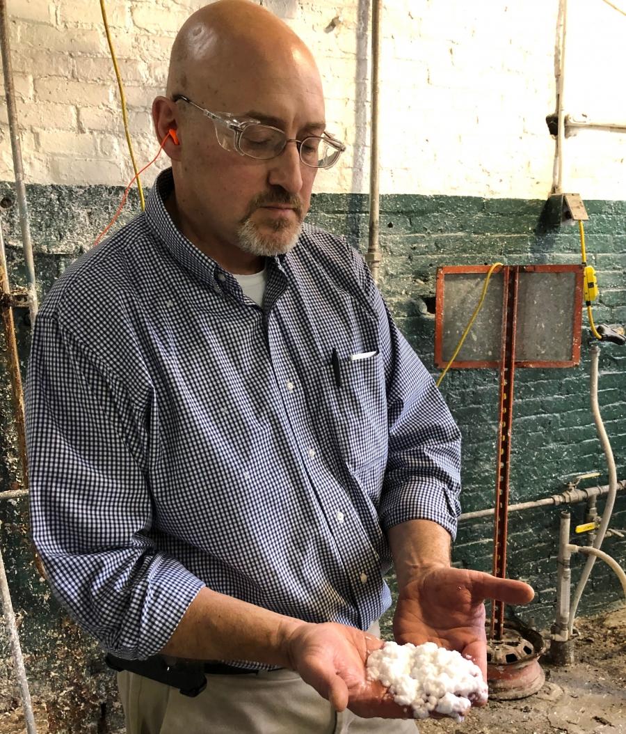 Early in the process, pulp fiber has a consistency and look that’s similar to oatmeal. Here, Paul Graver with Mohawk, holds an example.  