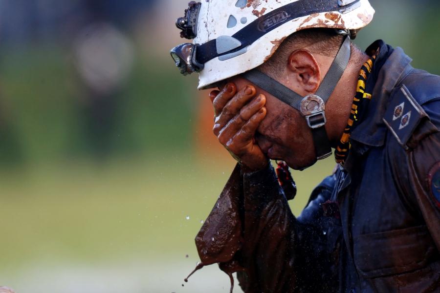 a rescue team member cries into his hands