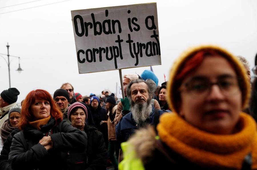 Protester man with beard holds sign against Orban. 