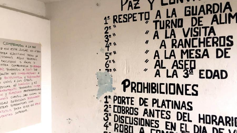 Writing in Spanish on a white wall. 