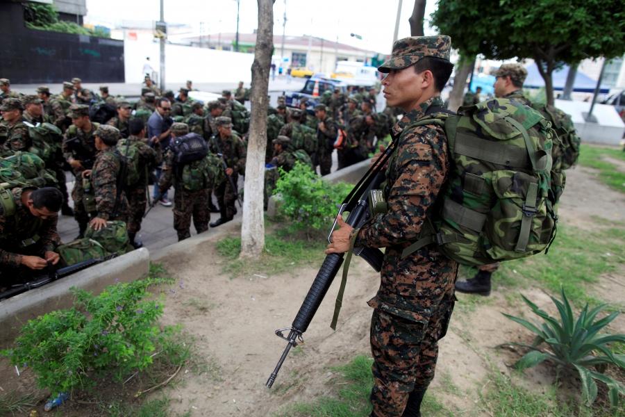 Salvadoran army reserve soldiers wait to board trucks after an official ceremony prior to their deployment to deal with gang violence in San Salvador,