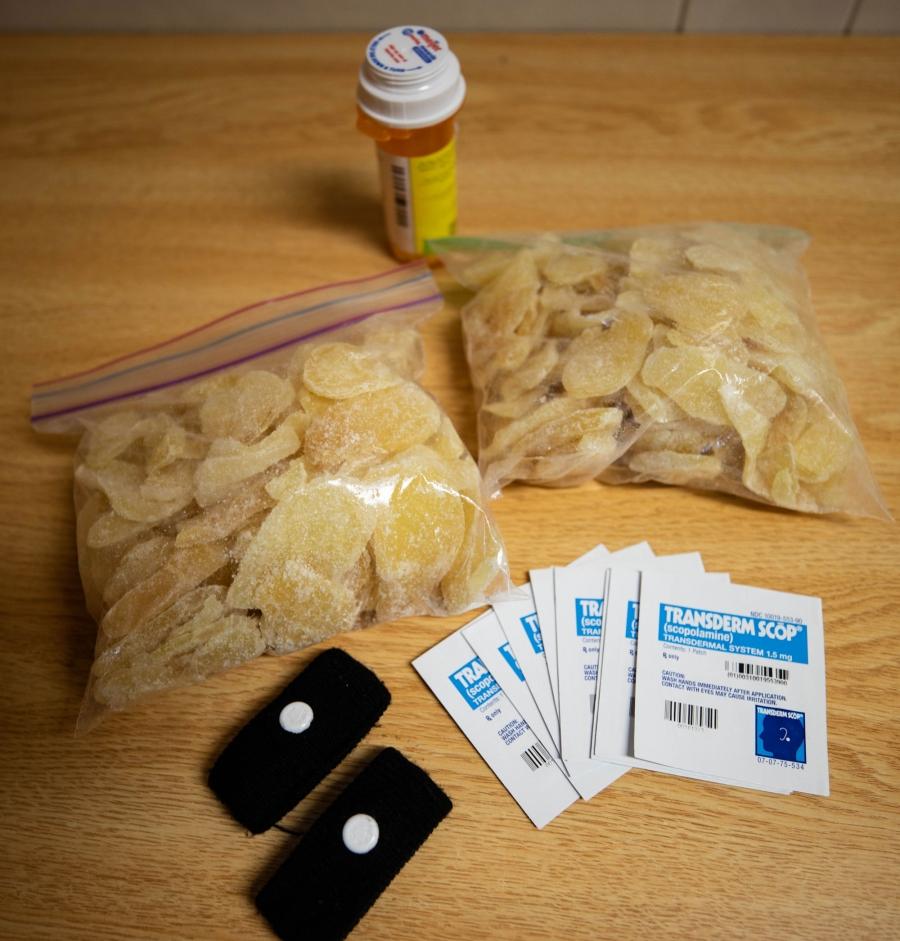 Seasickness patches, acupressure wristbands and crystallized ginger are shown on a table.
