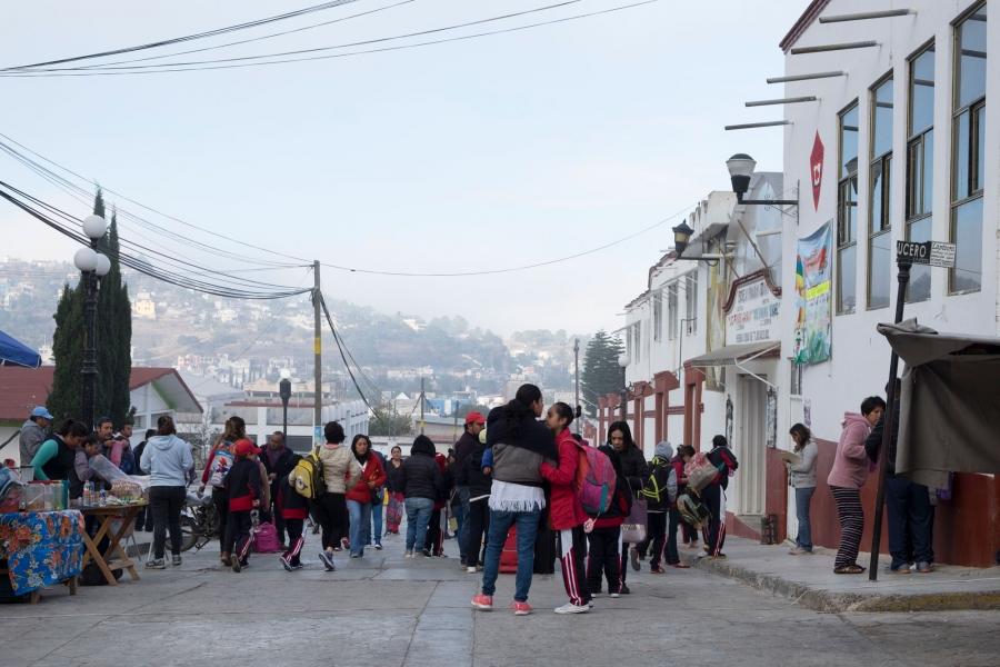 A group of people are shown outside of Tlaxiaco’s elementary school during morning drop-off.