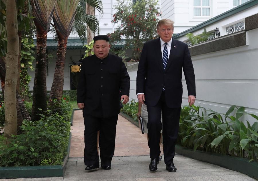 US President Donald Trump and North Korea's leader Kim Jong-un are shown walking side-by-side in a white-walled garden.